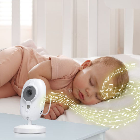 Bébé souriant et joyeux, allongé sur le ventre, regardant vers l'objectif, avec un babyphone blanc diffusant des notes de musique. Parfait pour illustrer la tranquillité et le bonheur du bébé sous surveillance.