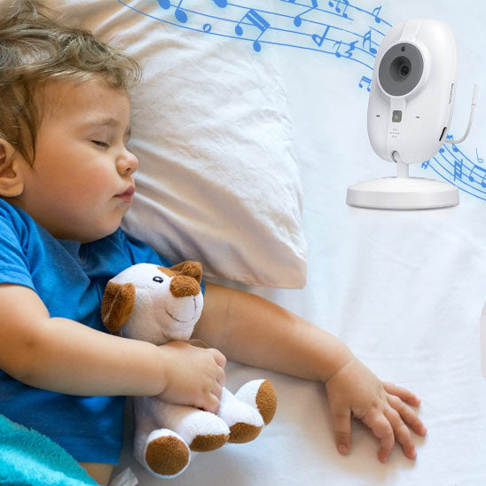 Babyphone blanc avec fonction berceuse près d'un jeune enfant endormi tenant une peluche, idéal pour surveiller le sommeil des plus grands.