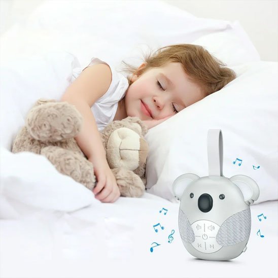 Famille heureuse avec bébé endormi paisiblement grâce à la veilleuse bruit blanc koala.