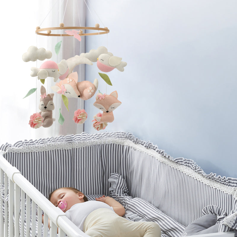 Bébé fille s'endormant paisiblement dans son lit en regardant un mobile musical.