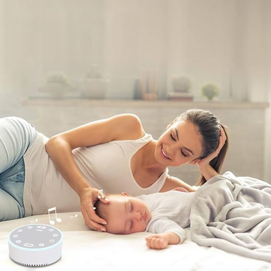 Maman souriante veillant sur son bébé endormi, avec la veilleuse bruit blanc dans la chambre.