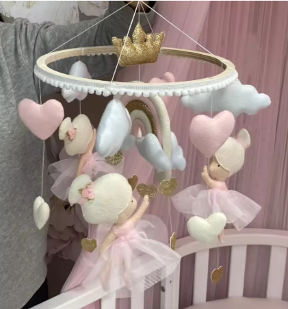 Mobile musical pour bébé fille avec des figurines roses et une boîte à musique, suspendu au-dessus d'un berceau.
