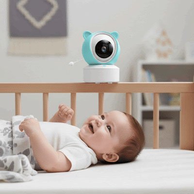 Parents souriants et sereins regardant leur bébé via un babyphone vidéo